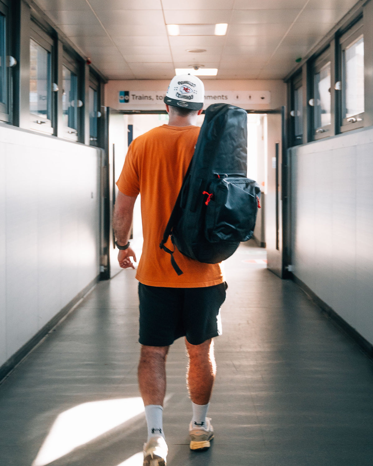 A player walking with the Racquet Bag Voyager worn as a backpack