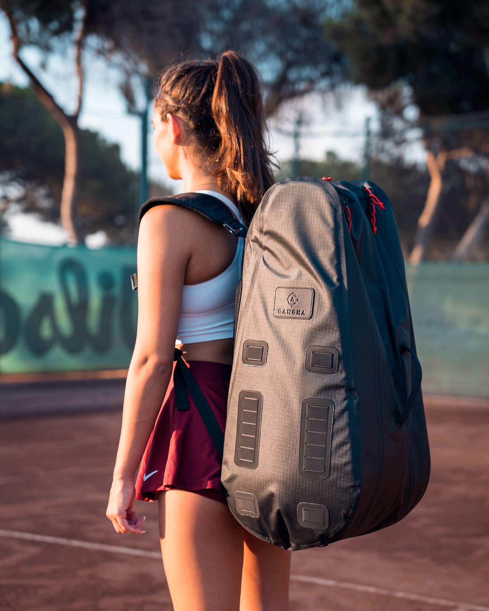 Person with a backpack on a tennis court