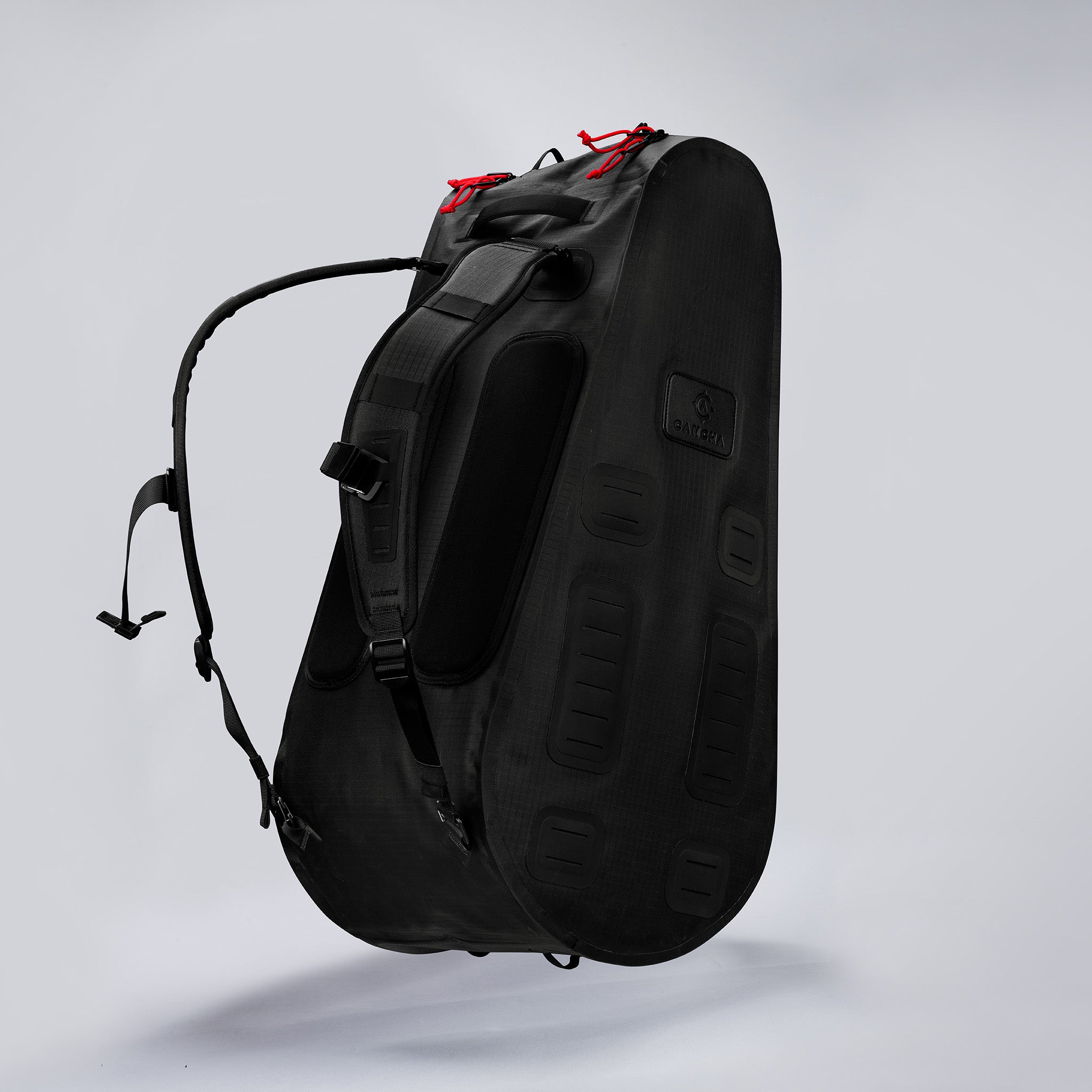 Black Cancha tennis backpack with red accents on a white background